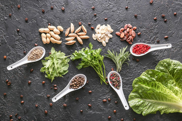 Different herbs, nuts and spices on dark background