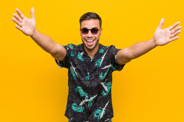 Young filipino man wearing summer clothes feels confident giving a hug to the camera.