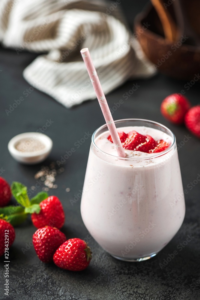 Wall mural Strawberry milkshake or smoothie in glass on black backgroud. Healthy vegan vegetarian food