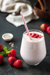 Strawberry milkshake or smoothie in glass on black backgroud. Healthy vegan vegetarian food