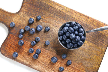 Scoop with fresh blueberry on wooden board