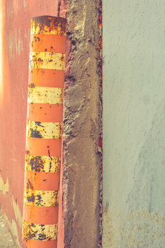 Old rustic Bollard or Traffic pole. Sign for cars with white and red stripes