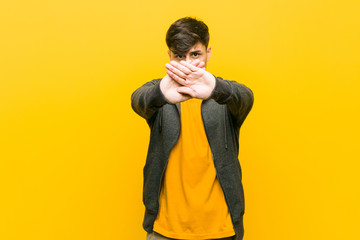 Young hispanic casual man doing a denial gesture