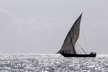 Fototapeta na wymiar single dhow sailboat silhouetted