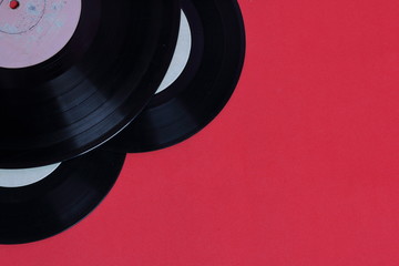 Old vinyl records. Worn and dirty. They lie on the surface of coral color.