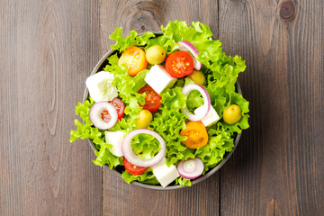Salad with vegetables on wooden background. Top view