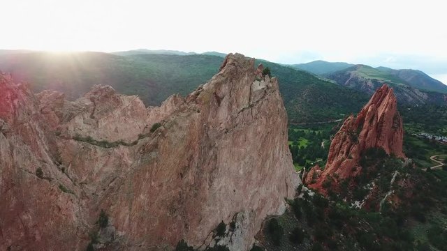 Aerial, tracking, drone shot, panning towards a sandstone mountain, at the Garden of the Gods, at sunset, on a sunny evening, in Colorado springs, USA