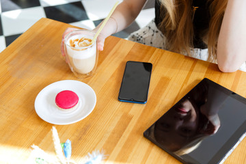 A working wooden desk table with notebook computer, tablet pc, mobile, hand phone, coffee glass latte