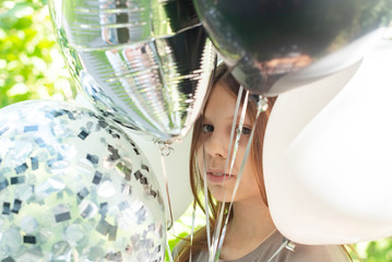 a girl with balloons outdoor