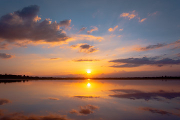 Sunset reflection lagoon. beautiful sunset behind the clouds and blue sky above the over lagoon landscape background. dramatic sky with cloud at sunset