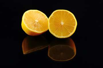 Photo of illuminated lemons with reflection on dark background