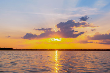 Sunset reflection lagoon. beautiful sunset behind the clouds and blue sky above the over lagoon landscape background. dramatic sky with cloud at sunset