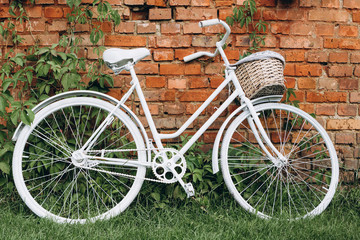 Fototapeta na wymiar City bicycle fixed gear and red brick wall, white vintage bike. Retro stylish cycling in town, old retro bike, cycling or commuting in city urban environment, ecological transportation concept