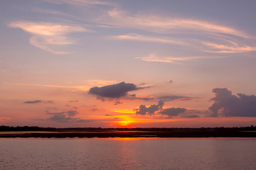 Sunset reflection lagoon. beautiful sunset behind the clouds and blue sky above the over lagoon landscape background. dramatic sky with cloud at sunset