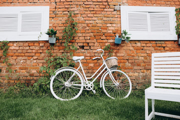 Fototapeta premium Vintage bicycle with basket parked near a window on the street with old brick wall and copy space.