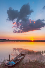 Obraz premium Sunset reflection lagoon. beautiful sunset behind the clouds and blue sky above the over lagoon landscape background. dramatic sky with cloud at sunset