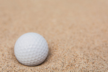 Selective focus of white golf ball on sand bunker