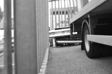 Fototapeta na wymiar Truck parked in yard with grey railing on road