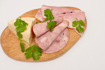 soft cheese and slices of meat on wooden board