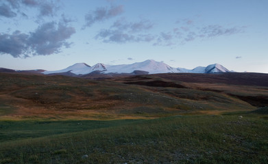 Fototapeta na wymiar Dramatic desert steppe highland mountain plateau with snow peaks