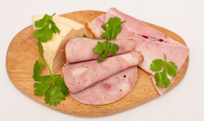 soft cheese and slices of meat on wooden board