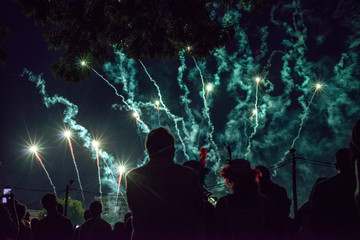 Fototapeta na wymiar Fireworks, smoke and crowd silhouette celebrating