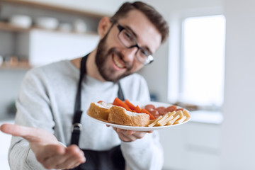 plate of sandwiches in the hands of an attractive man