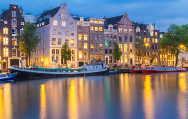 Fototapeta na wymiar Night city view of Amsterdam canal, typical dutch houses and boats, Holland, Netherlands.