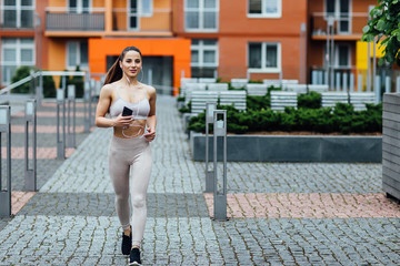 Strong athletic happy sportswoman wearing sport shorts  preparing running near home.