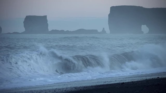 Waves crashing on black sand beach ocean rock formations Reynisfjara Dyrholey.mov