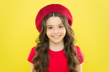 Adding an edge to the classic French look. Small child smiling with fashion look. Happy little girl wearing red beret for the ultimate cool girl look. Trendy look