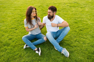 Couple in love cheerful youth booth props. Couple dating. Carefree couple having fun green lawn. Emotional people. Summer entertainment. Man bearded hipster and pretty woman cheerful faces. Youth day