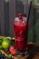 Summer berry Drink, Homemade Lemonade with berryes, strawberry, raspberry, blueberry, blackberry, mint, lime and crashed ice. Vertical view