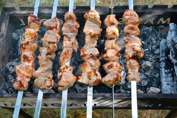 Marinated shashlik preparing on a barbecue grill over charcoal.