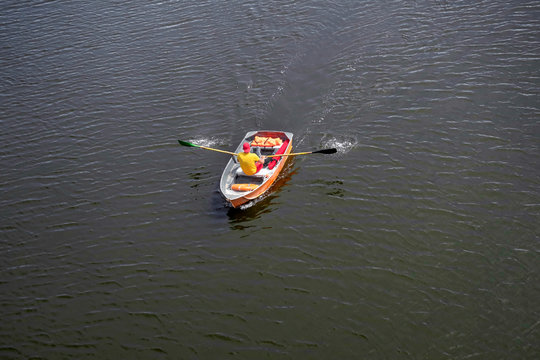 Lifeguard on a boat, rowing oars on the river. View from above.
