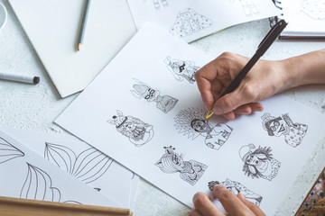 Animator designer draws sketches of various characters. Creating illustrations on paper for...