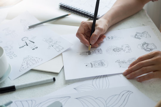 Animator Designer Draws Sketches Of Various Characters. Creating Illustrations On Paper For Cartoons Or Video Games.