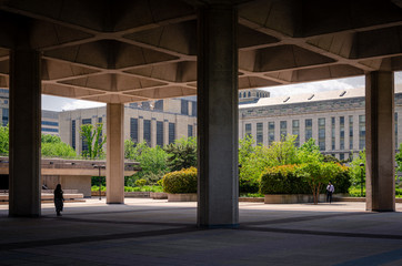 empty brutalist cantilevered plaza with huge concrete columns