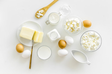 Fresh dairy products for breakfast with milk, cottage, eggs, butter, yougurt on white background top view