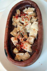 Delicious tripe with spices in the guvec (Turkish cuisine) on the restaurant table