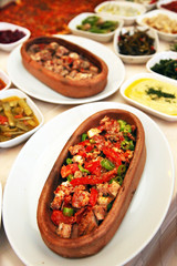 Delicious chicken with appetizer foods in the guvec (Turkish cuisine) on the restaurant table