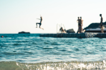 Floating platform in the sea, with teenagers having fun, out of focus