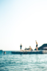 Floating platform in the sea, with teenagers having fun, out of focus - 278451979