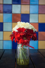 flowers in a jar on a table colorful background