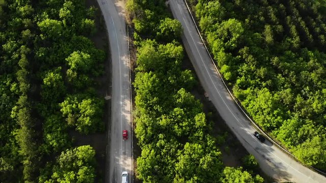Aerial view on a serpantine road with cars.