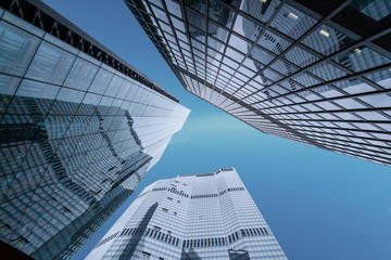 Concept of financial economics future. Business offices skyscrapers on blue sky background. Low angle view of tall corporate buildings.