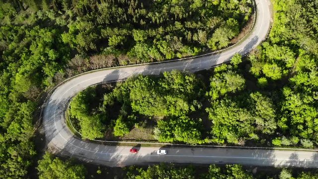 Aerial view on a serpantine road with cars.