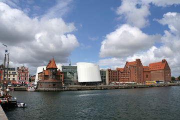Naklejka premium Lotsenhaus am Hafen, dahinter Ozeaneum und Stapelhäuser
