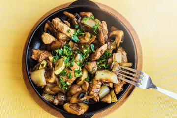 Fried potatoes with vegetables and meat in a pan.