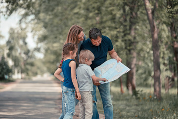 Fototapeta premium family with their children discussing the route on the map